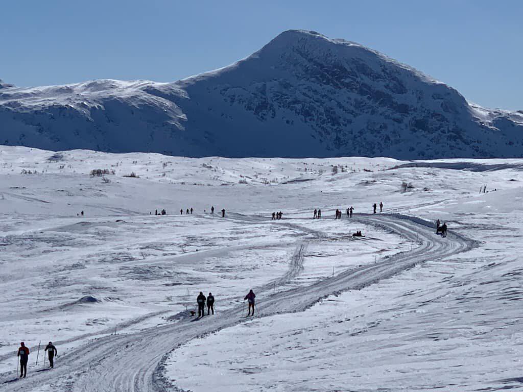 Skil&oslash;pere p&aring; vei innover fjell&oslash;ypa p&aring; Beiarfjellet, med en sn&oslash;dekt fjelltopp bak